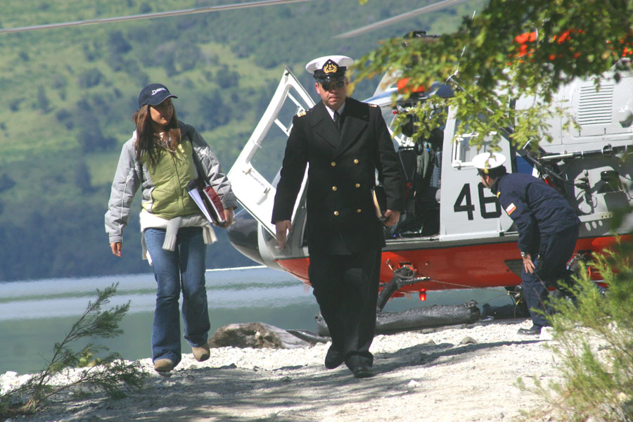 Vivianne Verschae en terreno junto a un oficial de DIRECTEMAR, con un helicóptero de la Armada de Chile